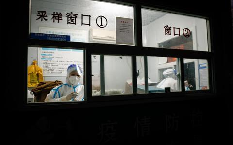 epaselect epa10324562 Health workers in protective suits inside a COVID-19 testing site in Beijing, China, 24 November 2022. The National Health Commission (NHC) recorded 31,444 COVID-19 cases on 23 November surpassing the previous peak of 29,317 recorded on 13 April in Shanghai. EPA/MARK R. CRISTINO
