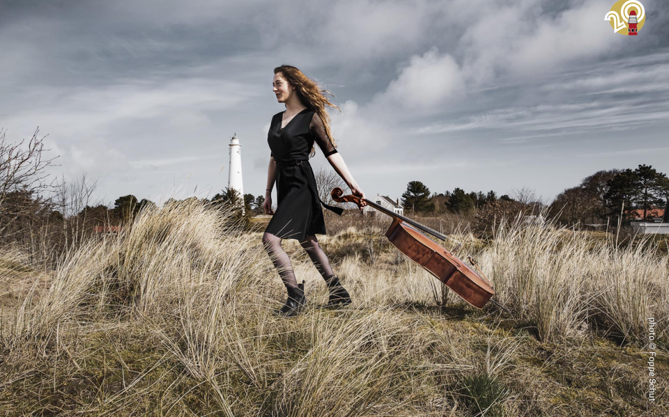 Florianne Remme sleept haar cello door de duinen op Schiermonnikoog.