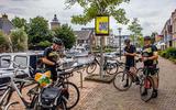 Drie fietsers uit België scannen in Sneek de QR-code.