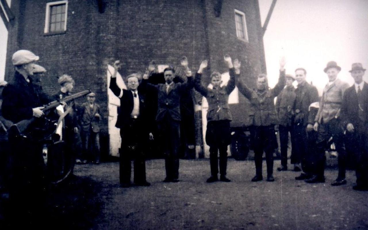 Herman Natkiel (links op de foto) houdt burgemeester Auke Ykema en twee Nederlandse SS-ers onder schot.