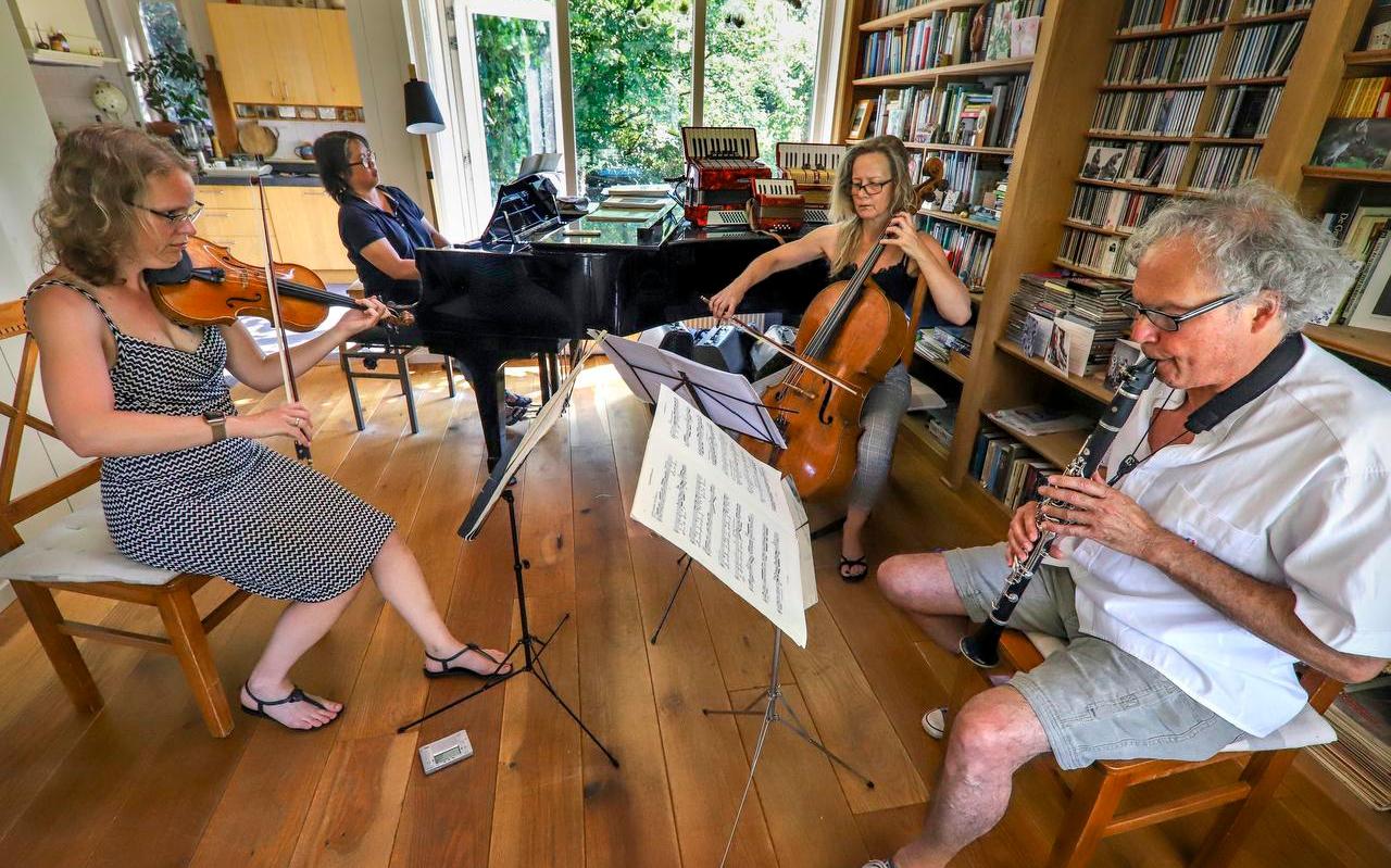 Violist Ingrid van Dingstee (l.), cellist Corien Kok en klarinettist Pierre Lafay repeteren bij echtpaar Hoite Pruiksma (producent) en Pauli Yap (pianist) thuis voor Tiid.