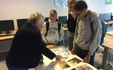 Jeanne Diele-Staal laat foto’s zien uit haar jeugd aan leerlingen van het Marne college in Bolsward.