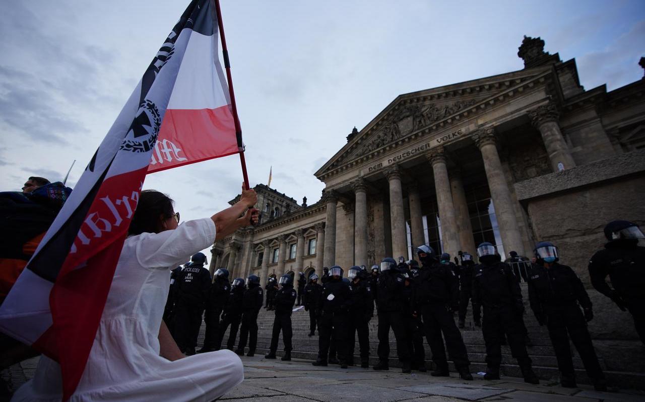 Een politiecordon beschermt het Rijksdaggebouw. Tienduizenden mensen waren zaterdag in Berlijn samengekomen om te protesteren tegen de coronamaatregelen die volgens de actievoerders hun mensenrechten schenden.