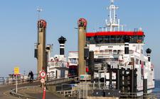 Verkeer verlaat in Holwerd de veerboot naar Ameland. Toerisme naar de Waddeneilanden kan nog een kwaliteitsimpuls krijgen, blijkt uit een symposium van gisteren. De focus zou niet alleen op aantallen mensen moeten liggen.