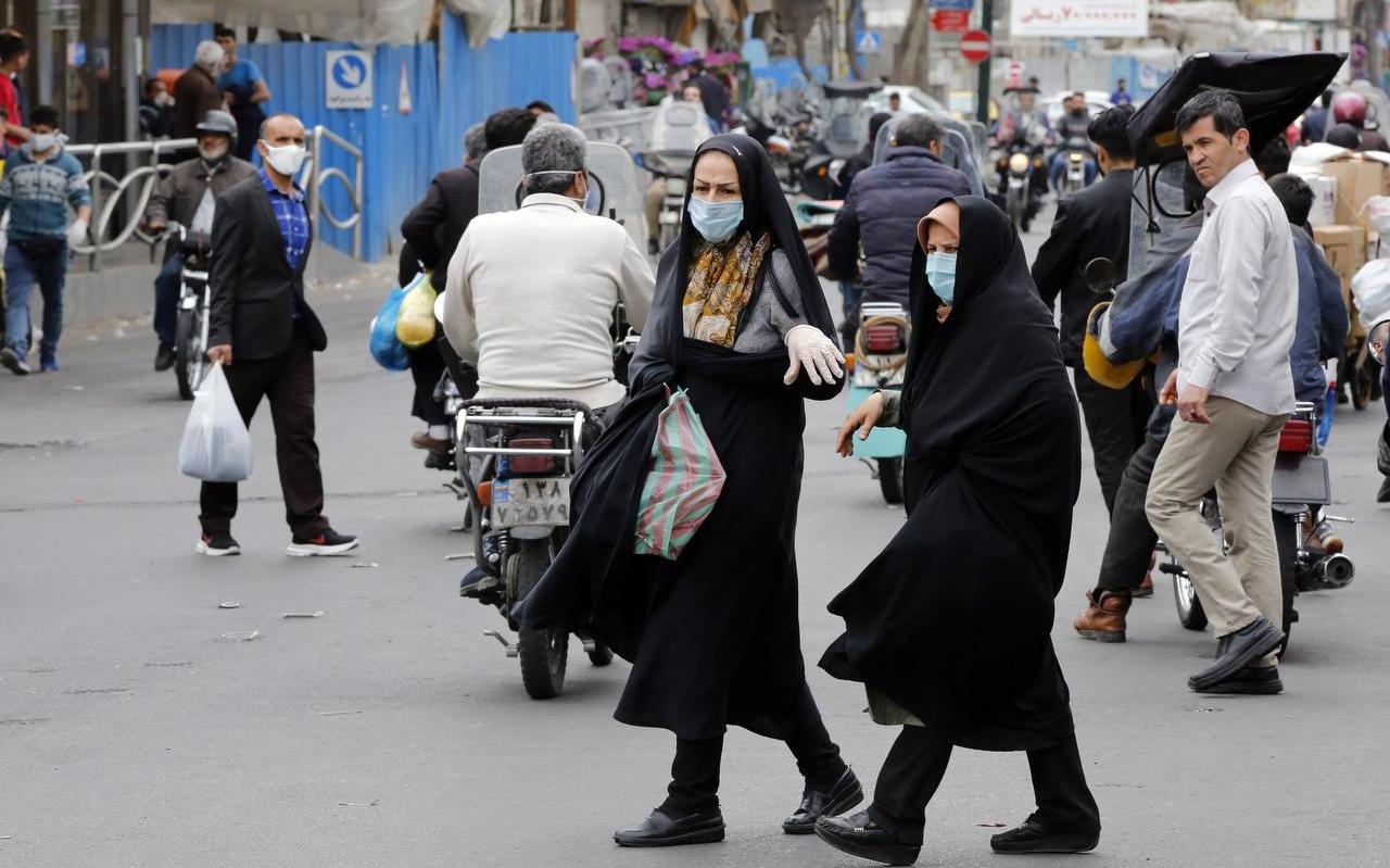 Iraniërs met mondkapjes op in een bazaar in Teheran.