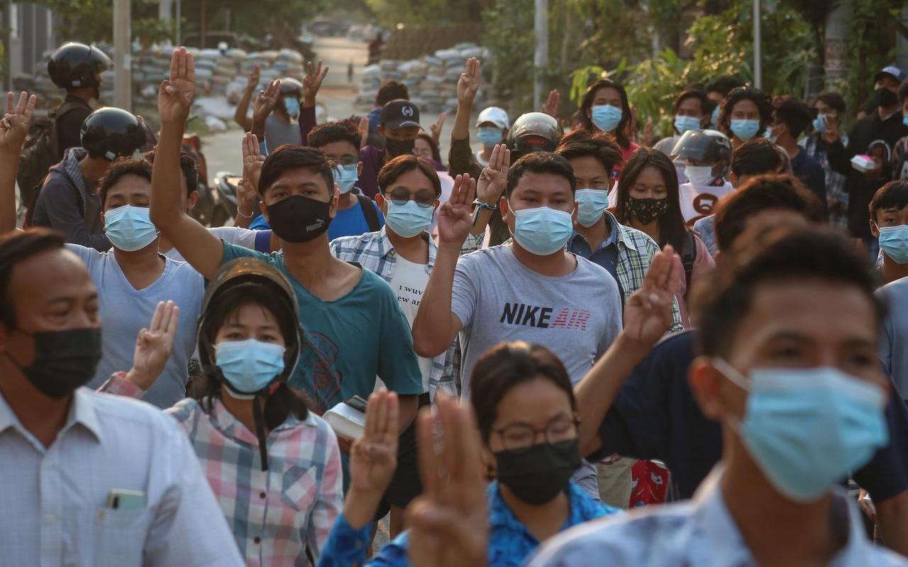 Demonstranten steken drie vingers in de lucht tijdens een protest tegen de militaire junta in de stad Mandalay in Myanmar.