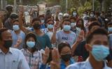 Demonstranten steken drie vingers in de lucht tijdens een protest tegen de militaire junta in de stad Mandalay in Myanmar.