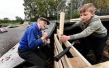 Martinus van der Meer (links) en Meinte Dijkstra zijn druk in de weer met hamers om een hut te bouwen op de skatebaan in Feanwâlden. Zo’n dertig jongeren uit het dorp willen het speelterrein nieuw leven inblazen.