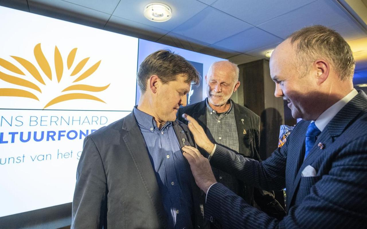 Arno Brok, voorzitter van het Prins Bernhard Cultuurfonds, overhandigt de Friese Anjer aan Cathrienus Herrema. Age Veldboom kijkt toe. Zij zijn de initiatiefnemers van  Myn Skip .