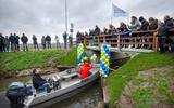 De jongste vrijwilliger, Hidde van der Wagen (8) met gele bouwhelm, van het project opent de nieuwe brug in Oosternijkerk.