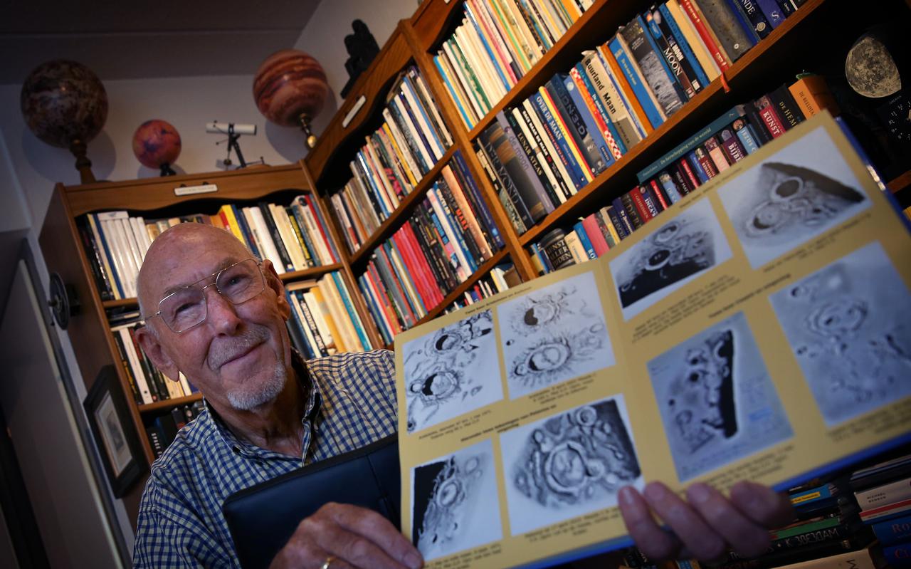 Henk Nieuwenhuis met zijn tekeningen van de maan en enkele van zijn zelfgemaakte globes op de achtergrond.