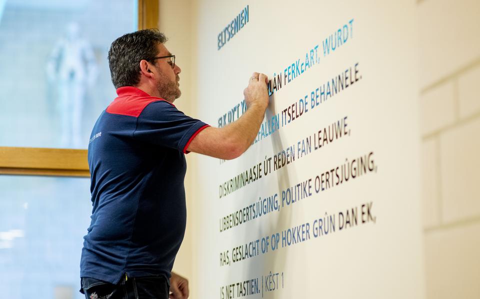 Ger de Vries van HR Groep/Wayfinding brengt in 2019 artikel 1 van de grondwet aan op de wand in het provinciehuis.