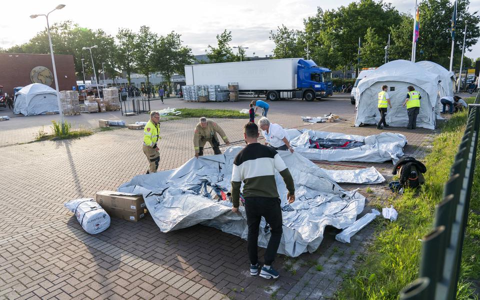 Hulpverleners van het Rode Kruis zetten tenten neer bij het aanmeldcentrum voor asielzoekers in Ter Apel. 