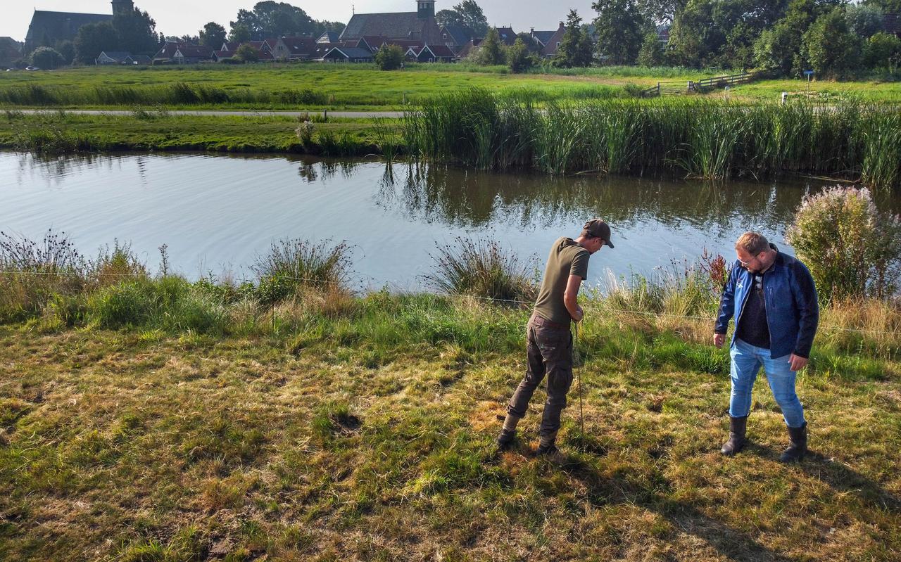 Jan Nutma (l) en Stefan Olie van Wetterskip Fryslân inspecteren de veendijk langs de Weisleat in Heeg. 