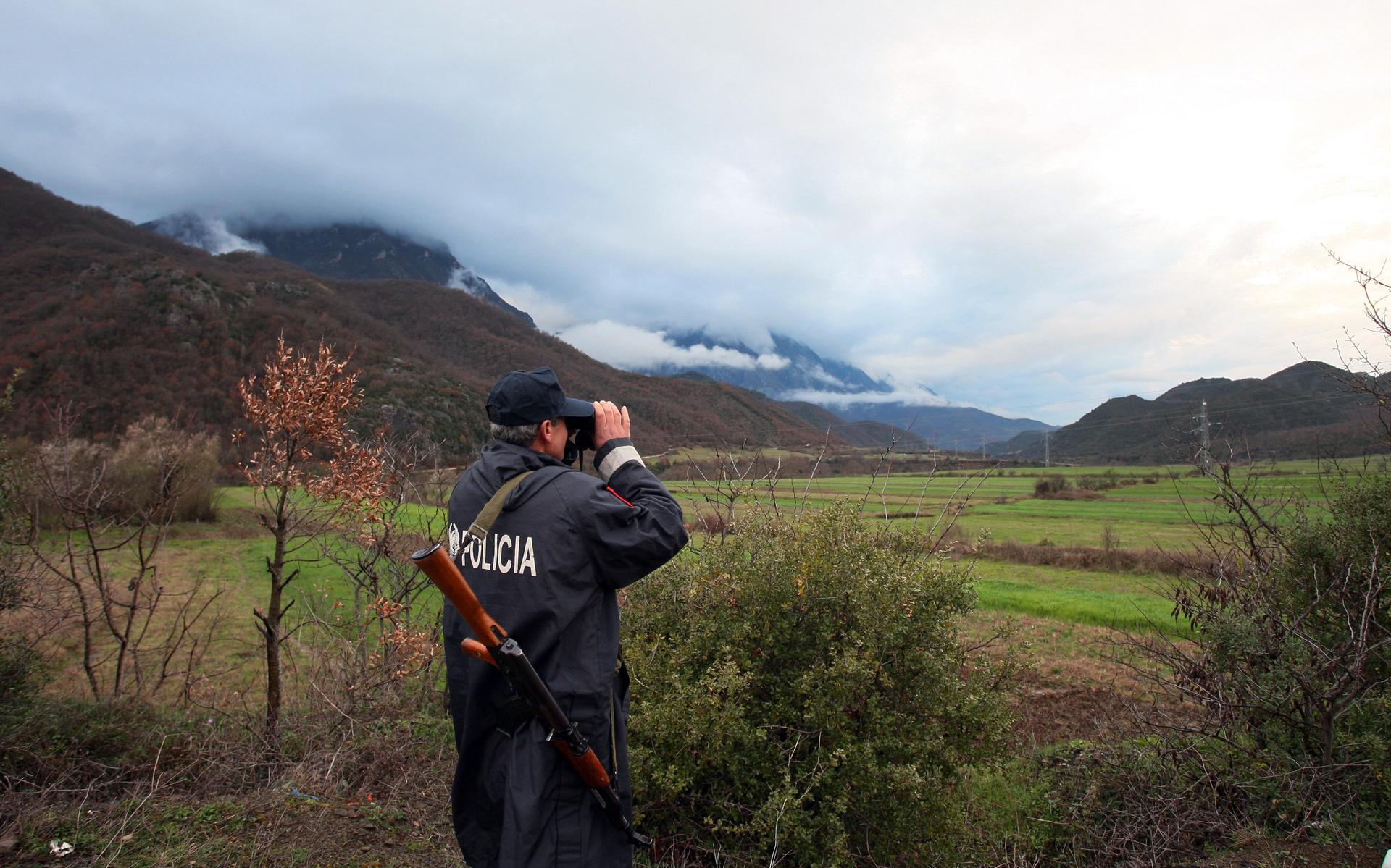 Een Albanese politieagent patrouilleert aan de grens met Griekenland. 