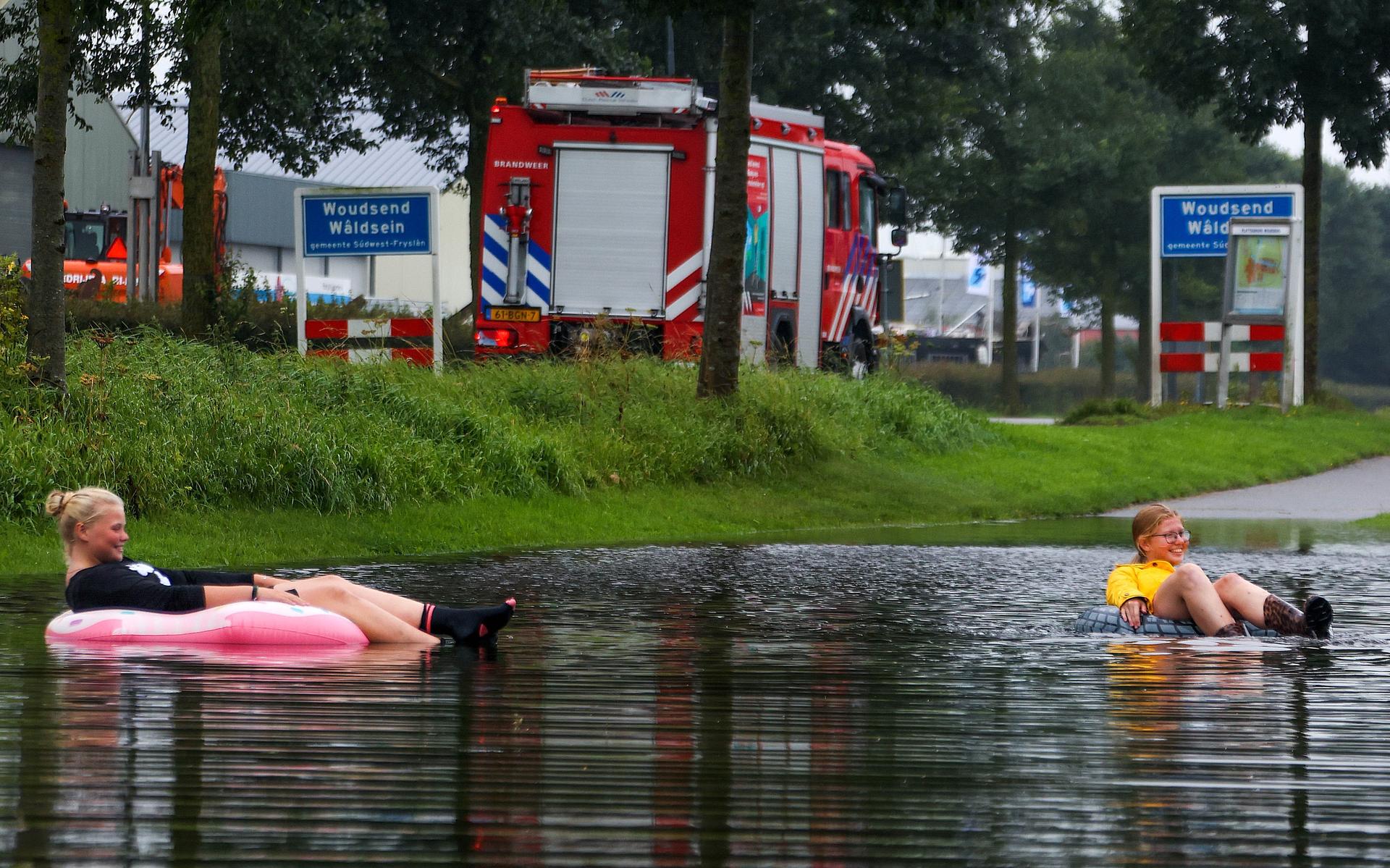 Zorgen over waterschade in Woudsend: het water stond tot aan de knieën, maar zorgde ook voor plezier