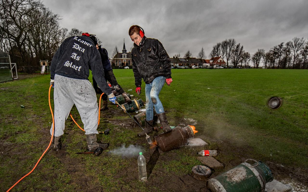 Carbidschieten op het kaatsveld in Niawier. Ze schieten op het kaatsveld. Leonard van Hijum steekt de bus aan. Elke deelnemer moest zelf zijn melkbus meenemen. 
