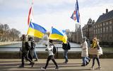 Demonstranten protesteren in Den Haag om te laten zien dat ze achter Oekraïne staan na de Russische invasie. Ze hebben Oekraïense vlaggen bij zich en borden met teksten als "Stop War" en "Stop Russia". 