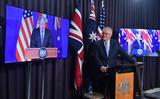 De Australische premier Scott Morrison kondigt het AUKUS-bondgenootschap aan, geflankeerd door de Britse premier Boris Johnson (l) en de Amerikaanse president Joe Biden op beeldschermen. 