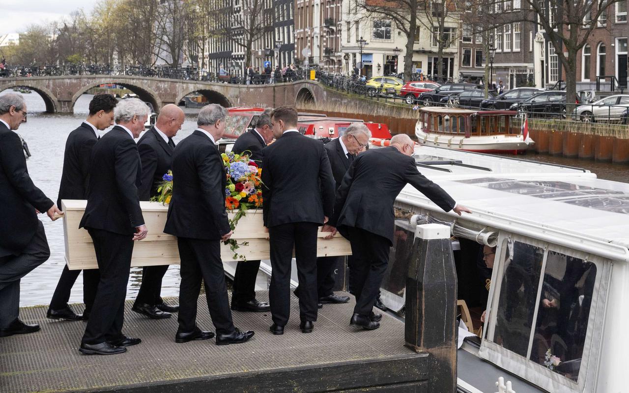 De kist met Huub Oosterhuis wordt na  de afscheidsdienst in de Westerkerk op een boot getild om hem naar de begraafplaats te varen.