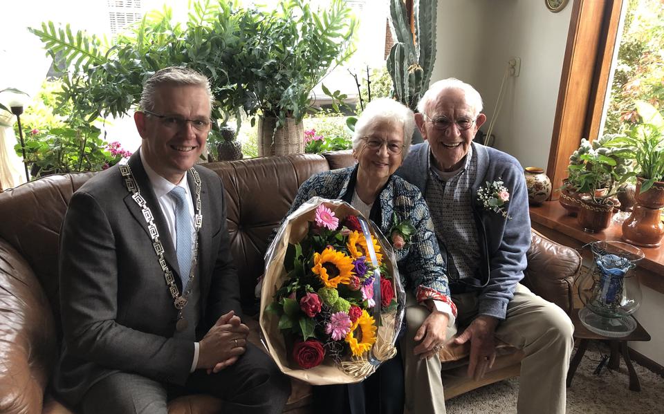 Burgemeester Jeroen Gebben van Tytsjerksteradiel verrast Hans en Tiny de Haan met een bezoek en een grote bos bloemen.
