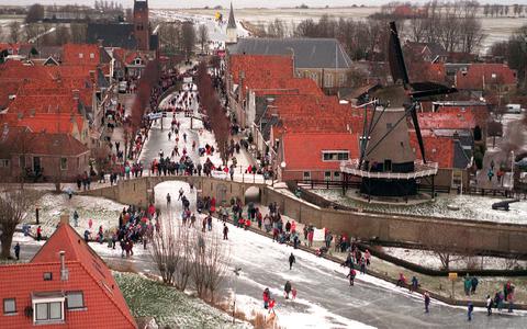 De molen bij Sloten. Hollandser kon het niet tijdens de 15e Elfstedentocht, toen de tourrijders passeerden.