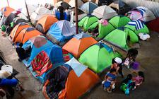 Migrantenfamilies uit heel Latijns-Amerika overnachten in tenten in ene hal in de Mexicaanse grensstad Tijuana omdat ze Amerika niet binnenkomen.