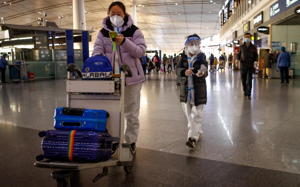 Passagiers op het vliegveld van Beijing, steeds meer landen voeren coronamaatregelen in voor reizigers die uit China komen. 