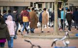 Afghanen komen aan bij basisschool De Oversteek in Nijmegen. Het migratiesaldo in Nederland  in het derde kwartaal was 48.700. 