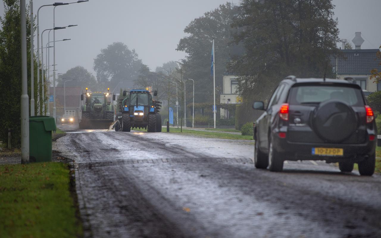 Met water en een borstel wordt de Rijkstraatweg in Hurdegaryp weer begaanbaar gemaakt. 