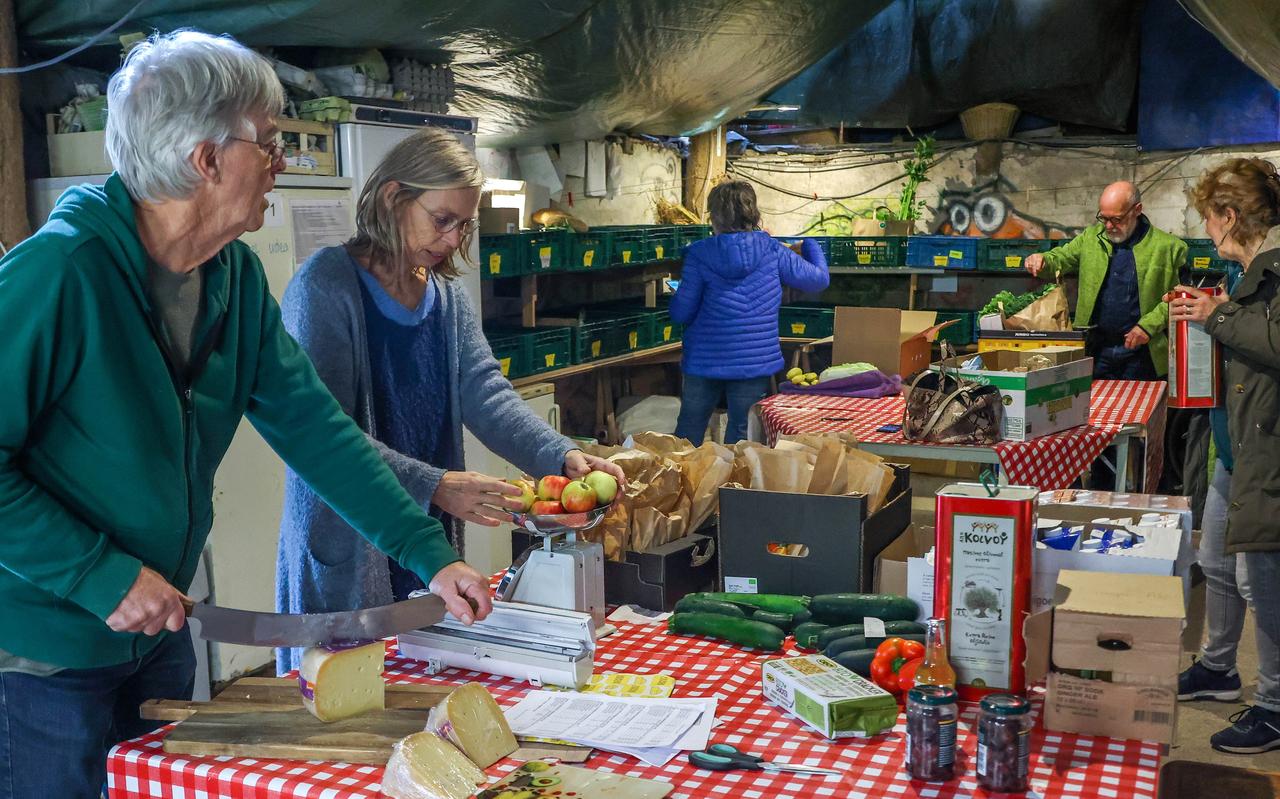 Buurtmarkt Us Iten in Sibrandabuorren. Klaas Douma (links) snijdt de kaas, daarnaast klant Minke van der Veer die de appels afweegt. Buurtmarkt Us Iten in Sibrandabuorren. Klaas Douma (links) snijdt de kaas, daarnaast klant Minke van der Veer die de appels afweegt.