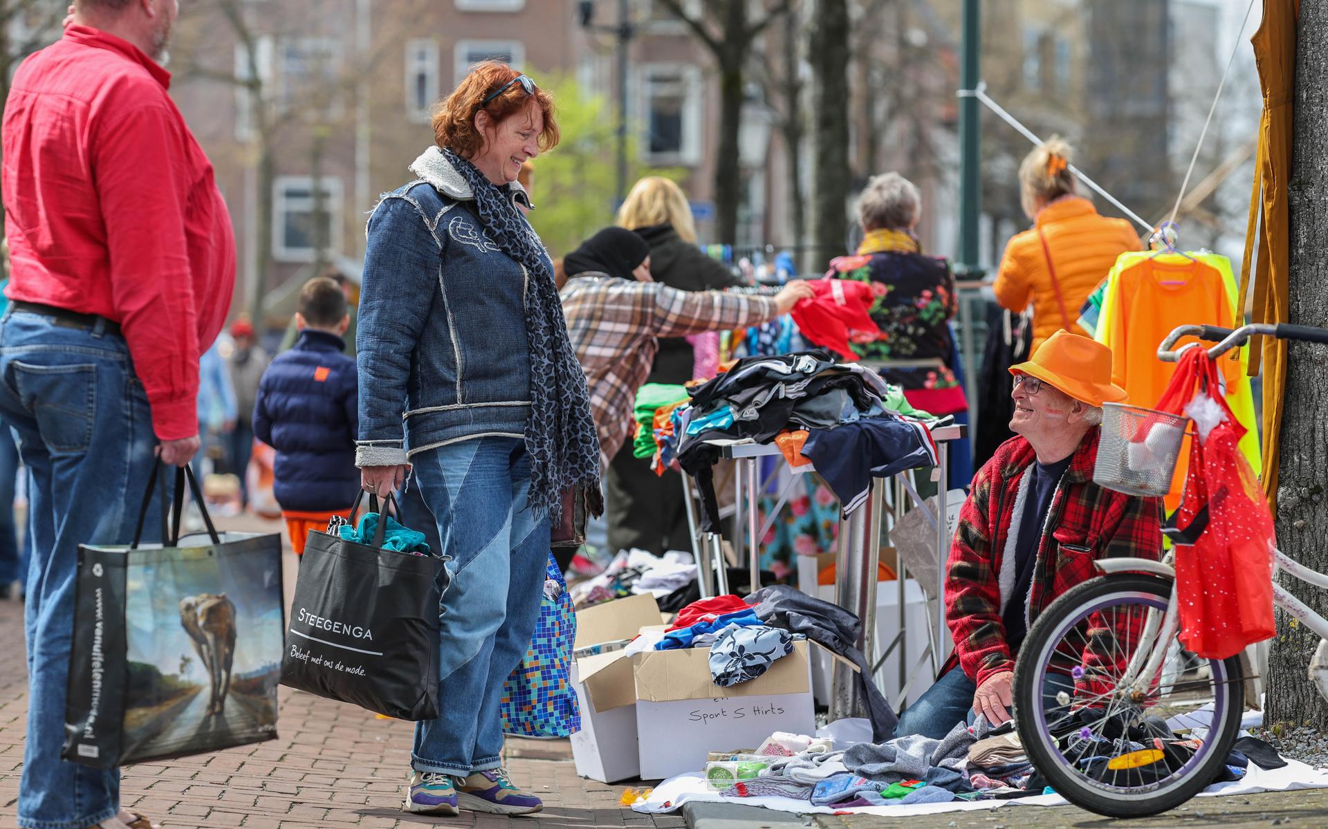 Froukje de Jong speurt naar koopjes bij Theunis Boonstra op de vrijmarkt in Heerenveen. 