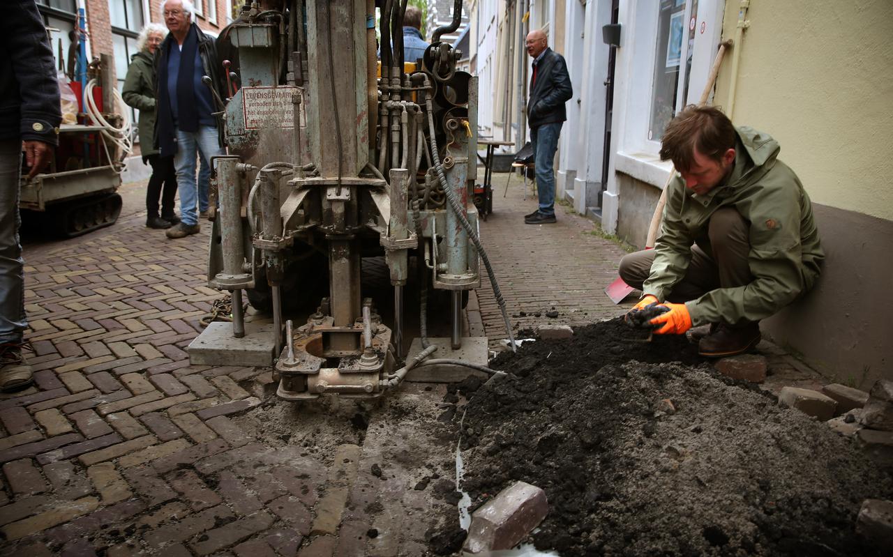 Jilles van Kesteren (rechts) zoekt naar archeologisch materiaal in de grond uit de terp Nijehove in de Grote Kerkstraat in Leeuwarden.
