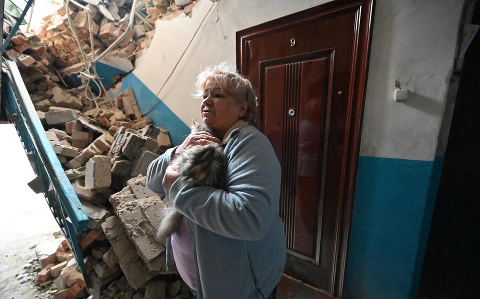 Een 70-jarige Oekraïense vrouw in het door een Russisch bombardement verwoeste portiek van haar flat in Kupiansk.  