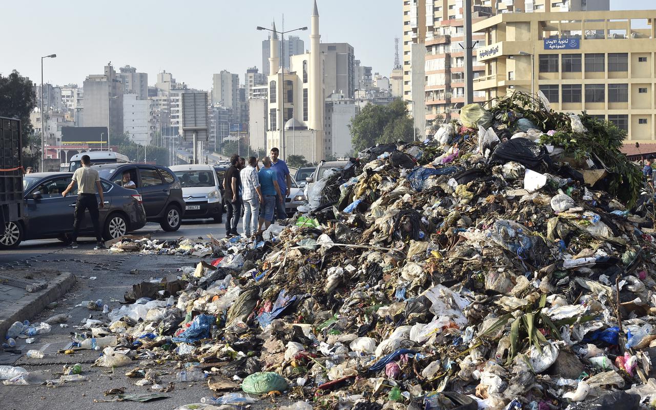 Betogers tegen het regeringsbeleid blokkeren een weg in Beiroet met huisvuil, juli 2021.