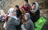 Afghaanse kinderen eten samen een brood op. Volgens de Verenigde Naties hebben bijna 23 miljoen mensen, circa 55 procent van de bevolking, te maken met extreme honger. 