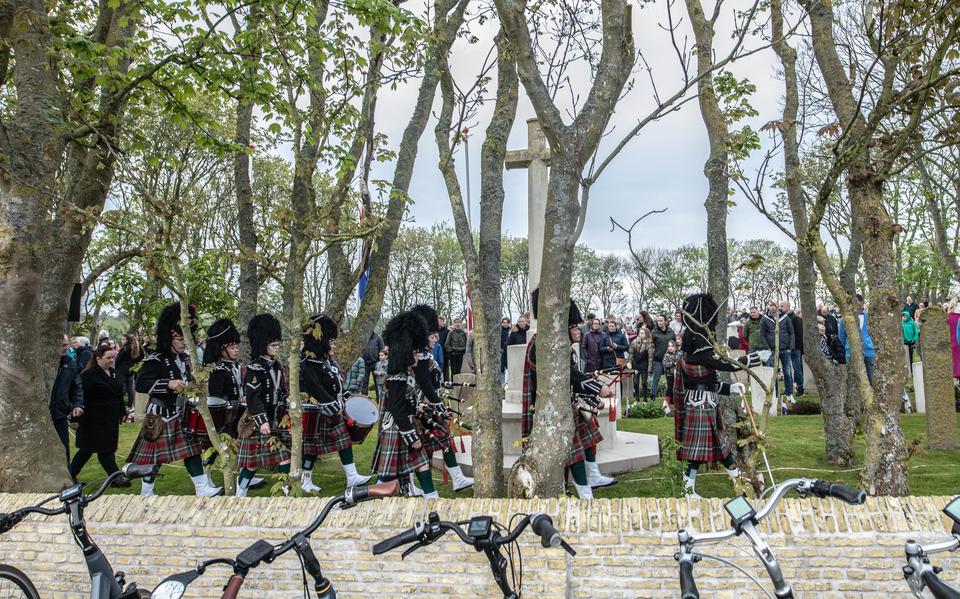 De Amelander Pipe and drums band The Islanders lopen voorbij het monument op de Algemene en Common Wealth-begraafplaats in Nes op Ameland voor de kranslegging op 4 mei. 