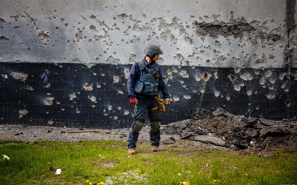 Een lid van een Oekraïense ontmijningsdienst op zoek naar niet ontplofte explosieven in Kharkov. 