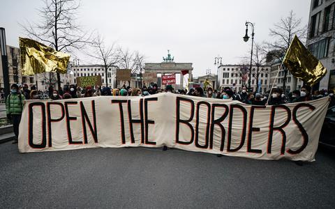 Betogers in Berlijn eisen dat de migranten in het Pools-Belarussische grensgebied tot de EU worden toegelaten. 