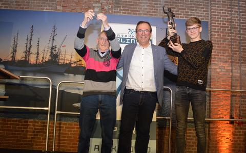 Auke Pollema (l) ontvangt de aanmoedigingsprijs, voorzitter Johan Schikker en Wytse Broekstra met de Hotze Schuil Trofee. 