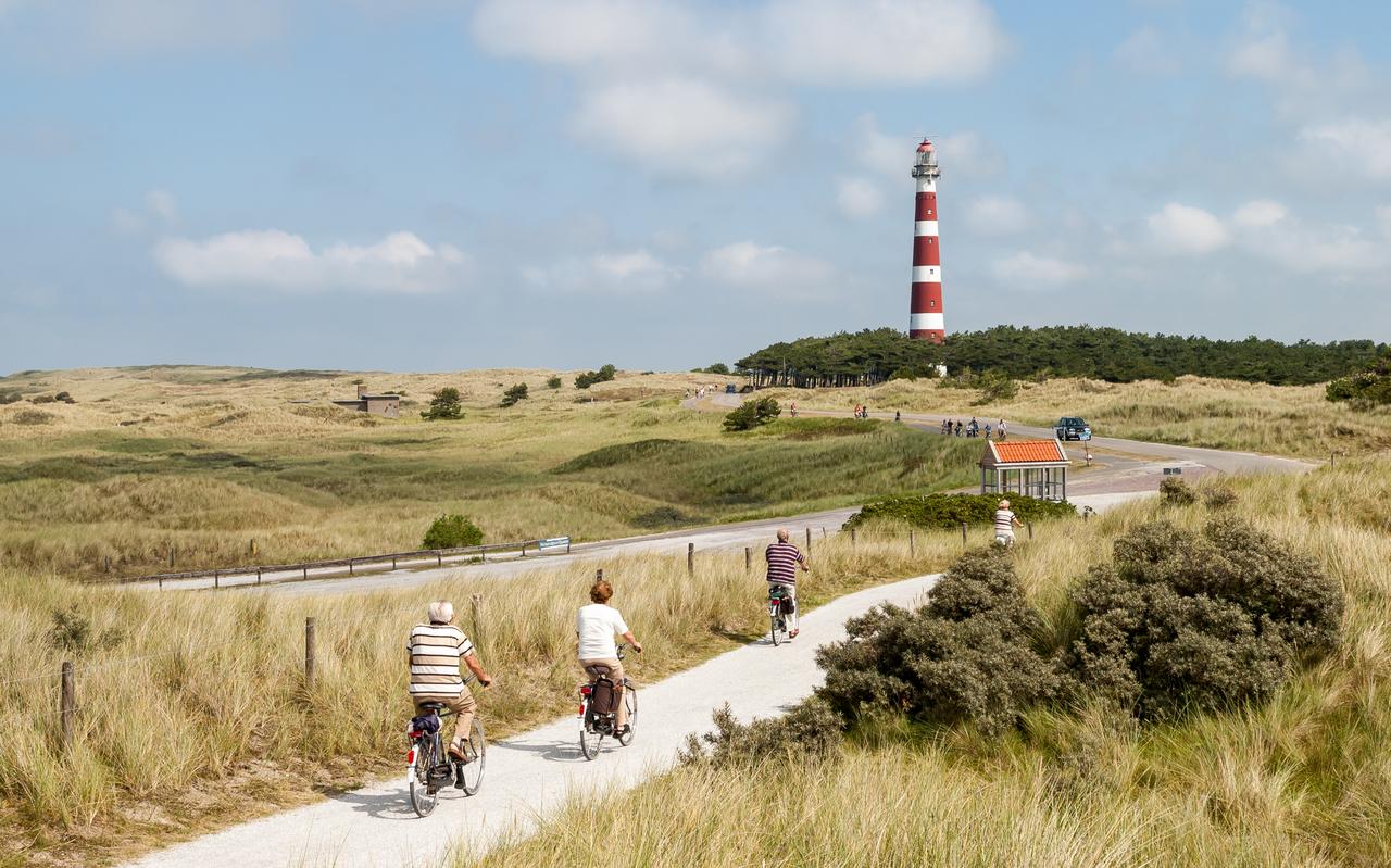 Toeristen op de fiets in de duinen van Ameland. Toeristen op de fiets in de duinen van Ameland.