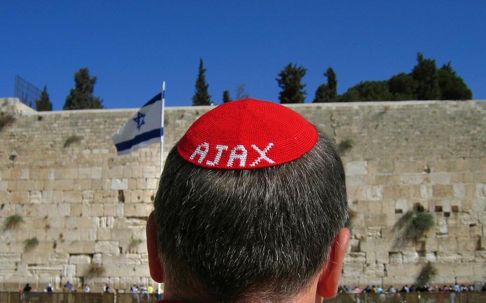 Een fan van Ajax bekijkt in 2004 in Jeruzalem de Klaagmuur, met een zelfgemaakt keppeltje op.