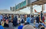 Op het vliegveld van Kabul wachten vele Afghanen in de hoop geëvacueerd te worden na de machtsovername van de taliban.