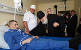 Patriarch Kirill van Moskou bezoekt een Russische militair in het ziekenhuis.