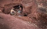 Arbeiders in een open goudmijn in Tanzania. Illegaal gewonnen goud en andere edele metalen worden op de reguliere markt gebracht, wat enorme winsten oplevert voor handelaren.