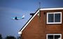 Een vliegtuig vliegt over een woning in de omgeving van Schiphol. 