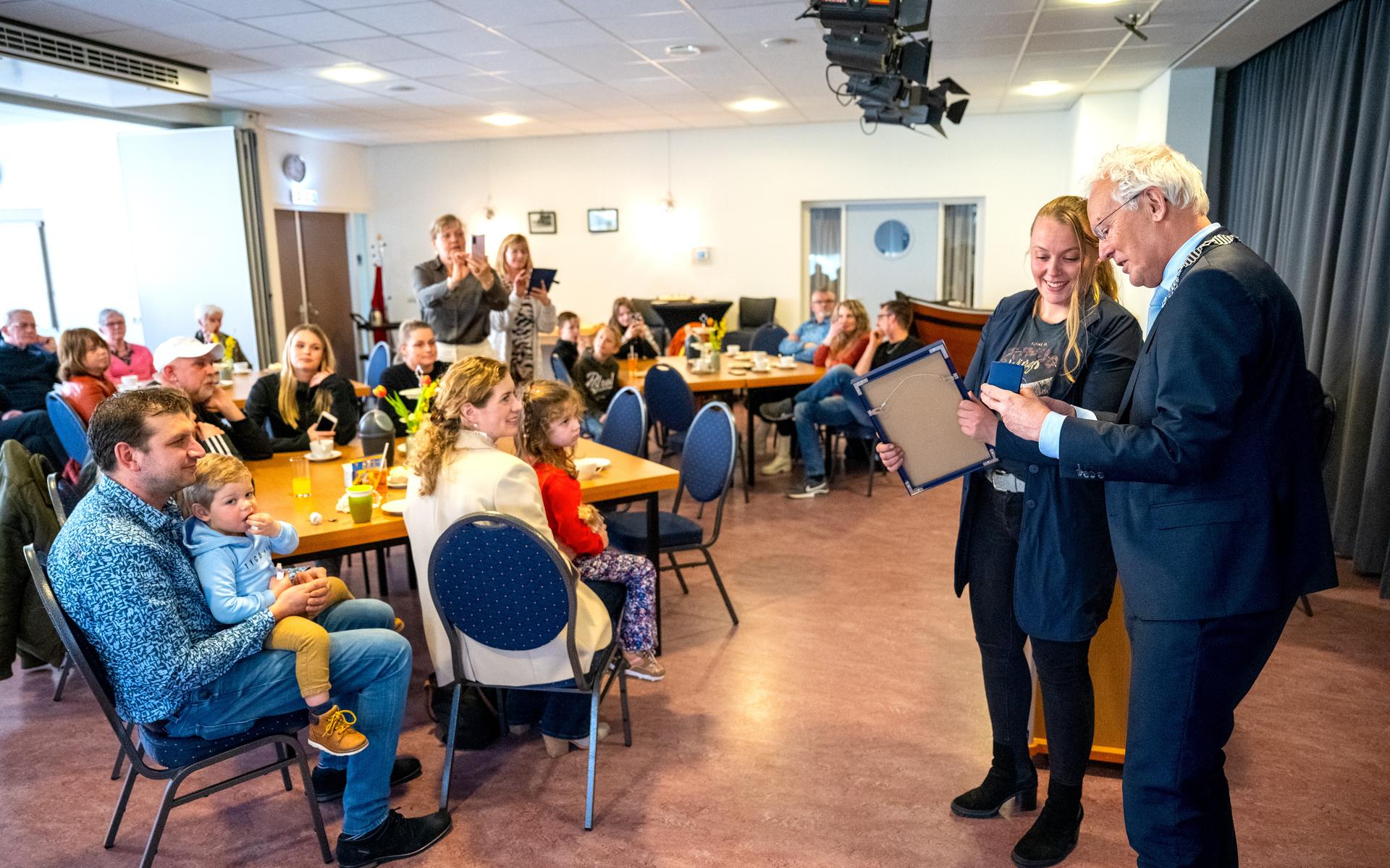 Stephanie Pijpker krijgt uit handen van burgemeester Jan Rijpstra een zilveren medaille en oorkonde van de Koninklijke Maatschappij tot Redding van Drenkelingen uitgereikt.