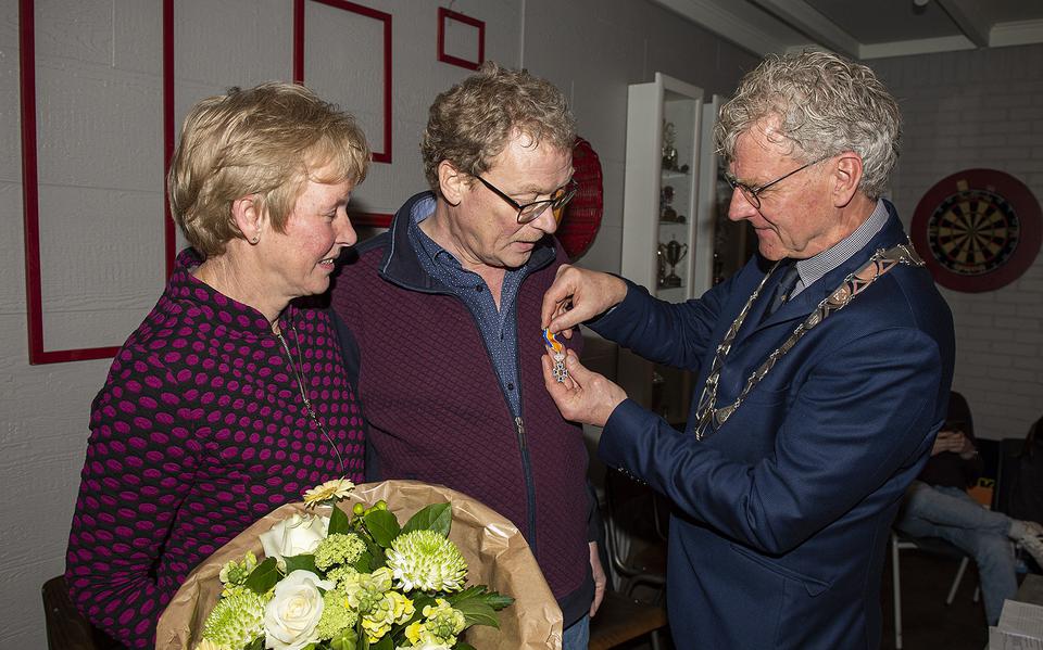 Burgemeester Oebele Brouwer (rechts) van Achtkarspelen spelt Wobbe de Haan de koninklijke onderscheiding op.