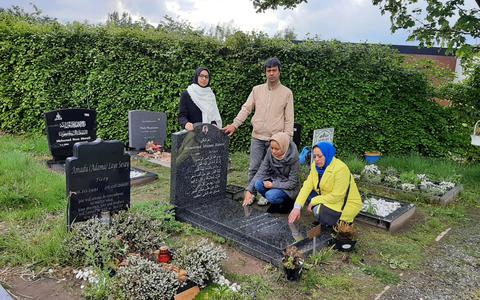 Het gezin Rahimi bij het graf van hun verdronken zoon en broer Meesam op begraafplaats Zuylen in Breda. 