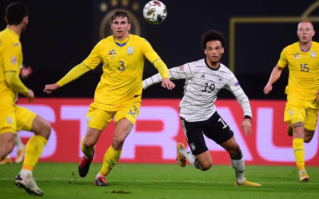 Illia Zabarnyi (l) van Oekraïne houdt de Duitser Leroy Sané van de bal. Illia Zabarnyi (l) van Oekraïne houdt de Duitser Leroy Sané van de bal.